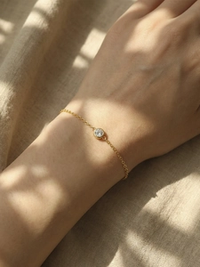 Nahaufnahme des minimalistischen 18k vergoldeten Kettengliedarmbands mit Zirkon am Handgelenk