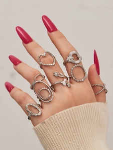 Detail of silver geometric heart rings set on a hand with soft cream knit sweater