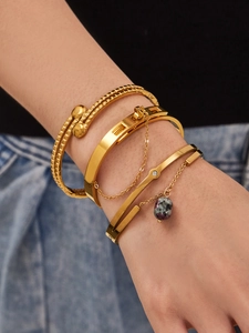 Détail de l'ensemble de quatre bracelets dorés avec pendentif en pierre et fini texturé