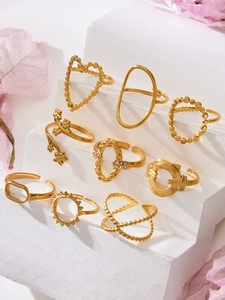 Close-up of golden geometric heart ring set with sparkling zircon on white stone