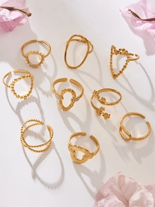 Set of nine golden geometric heart and floral open rings in varied minimalist designs