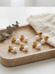 Gros plan sur trois paires de boucles d'oreilles cœur en or 18 carats avec perles