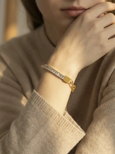 Close-up van gouden armband met zirkoonstenen gedragen door een vrouwelijk model