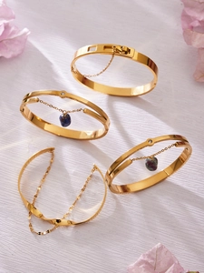 Détail de quatre bracelets en acier doré avec pendentifs en pierre naturelle et zircons