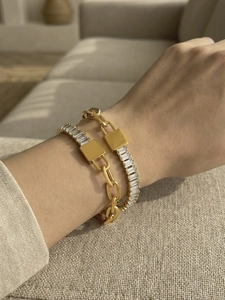 Detail van vergulde Cubaanse schakelarmband met slot en baguette-zirkonia tennisarmband