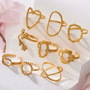 Golden geometric heart and flower open ring set on white steps with pink petals