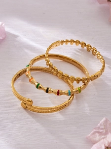Détail de trois bracelets en acier inoxydable doré avec textures de pierre et bambou