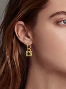 Gros plan d'une boucle d'oreille cadenas dorée avec incrustation de malachite