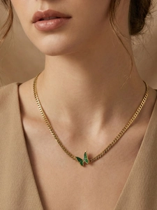 Close-up of a 18k gold-plated Cuban chain necklace with a green enamel butterfly pendant