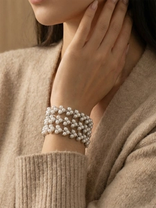 Gros plan d'un bracelet de perles multicouche avec finition argentée sur le poignet