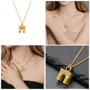 Detailed views of the golden Arc de Triomphe pendant necklace on model and rock background