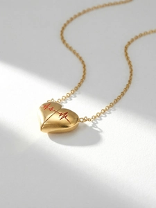 Dettaglio macro del ciondolo a cuore dorato con trama a battito cardiaco rosso spazzolato