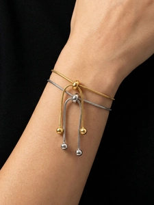 Close-up of adjustable snake bone bracelets in gold and silver finish on wrist