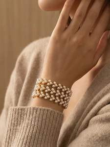 Détail d'un bracelet manchette multicouche en perles avec monture en métal doré 18 carats