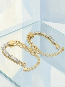 Macro detail van een 18K vergulde schakelarmband met rechthoekige zirkonia-stenen
