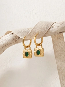 Détail de boucles d'oreilles cadenas dorées avec pierre ovale verte rétro