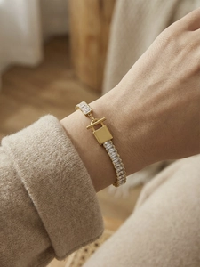 Macro di bracciale a catena dorata con zirconi e chiusura a lucchetto dal design unico