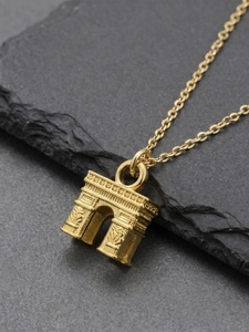 Detailed view of the Arc de Triomphe pendant on a textured grey stone surface