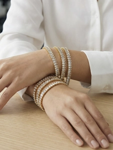 Dettaglio di eleganti bracciali a catena placcati oro con zirconi con taglio baguette
