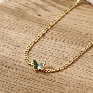 18k gold-plated Cuban link necklace featuring a green enamel butterfly pendant on wood