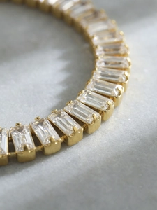 Vista macro del bracciale placcato oro 18k con zirconi taglio smeraldo e chiusura a OT