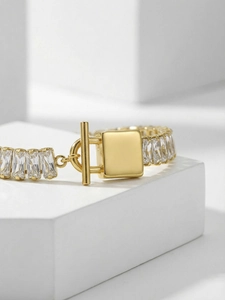Vista macro di bracciale a catena dorato con zirconi e chiusura a levetta a T