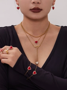 Détails d'un ensemble de bijoux en forme de cœur doré avec colliers et bagues sur un mannequin