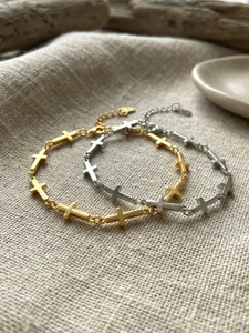 Detail of gold and silver cross link bracelets with lobster clasp and extension chain