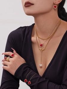 Gros plan d'un ensemble de bijoux coeur rouge avec collier et bagues dorés