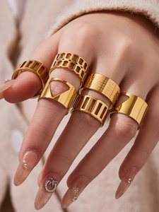 Gros plan d'un ensemble de 6 bagues en acier plaqué or 18k portées par un mannequin