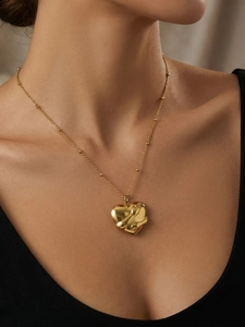 Detail of gold-plated stainless steel heart pendant necklace on a female model