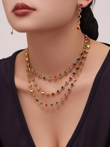 Luxuriöses Set aus mehrlagiger Edelstahlkette und bunten Quastenohrringen am Modell