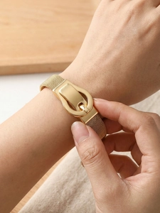 Detail of golden Milanese mesh bracelet showing the horseshoe buckle and metallic texture