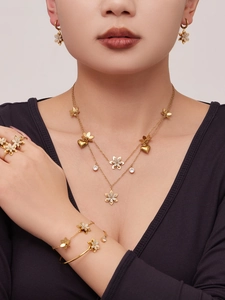 Dettaglio del set di gioielli floreali dorati con zirconi 5A indossati da una modella