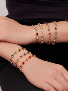 Detail von bunten runden Zirkonia-Armbändern aus vergoldetem Edelstahl an einem Modell