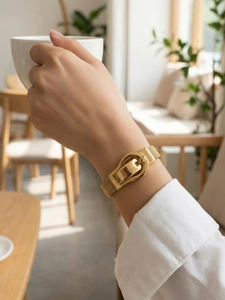 Close-up of golden mesh watchband bracelet with horseshoe buckle on model wrist