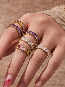 Dettaglio di anelli placcati in oro 18k con zirconi triangolari su una mano