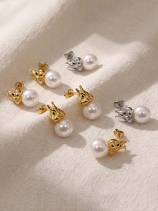 Vue détaillée de boucles d'oreilles perles en forme de lapin en doré et argent