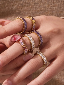 Primo piano di anelli eternity in zircone multicolore taglio cuore placcati oro 18 carati
