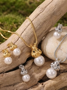 Vue détaillée du coffret bijoux écureuil et perles sur fond de mousse et bois
