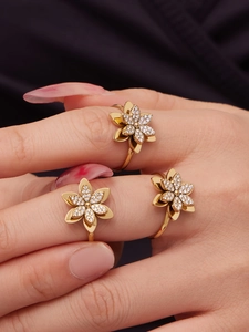 Dettaglio di tre anelli a fiore in oro sovrapposti con zirconi 5A incastonati a pavé