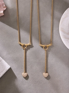 Détail du collier en Y doré avec fermoir main et pendentif cœur serti de zircons