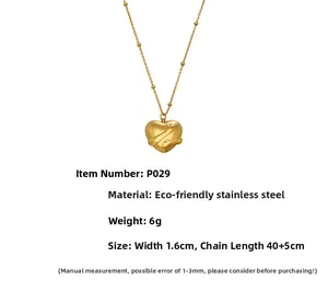 Detail of gold heart pendant with liquid metal texture and beaded stainless steel chain