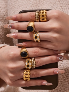 Detail of vintage gold-plated rings with black and white checkerboard enamel pattern