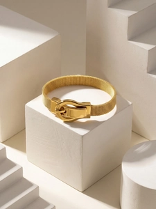 Detailed macro view of the golden mesh watch band with polished horseshoe buckle closure