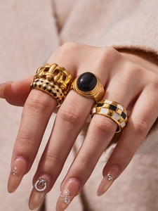 Detail of 18k gold plated checkered enamel rings and black stone statement ring
