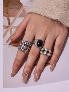 Detailed close-up of 18k gold plated checkered enamel and black onyx ring set for women
