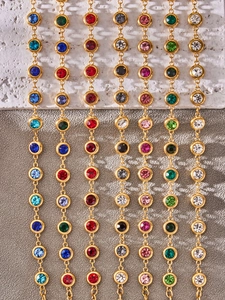 Detail einer Goldkette mit bunten runden Zirkonia-Steinen in einer Zargenfassung