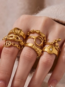 Detailed view of French-style gold geometric stackable rings on a female hand