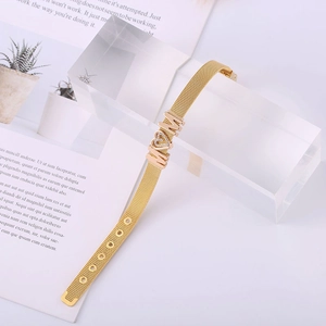 Detail of gold mesh band bracelet with MOM letters and sparkling heart charm accessory